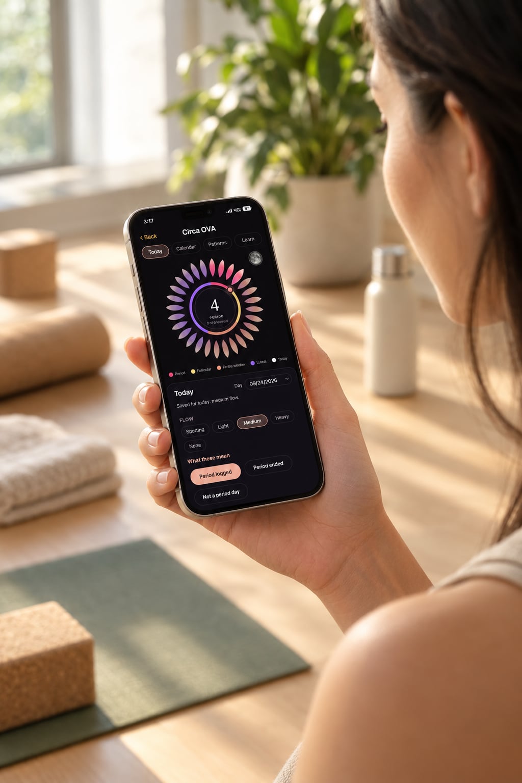 A woman holding her phone with Circa OVA open: the Bloom on day 4, her flow logged with one tap